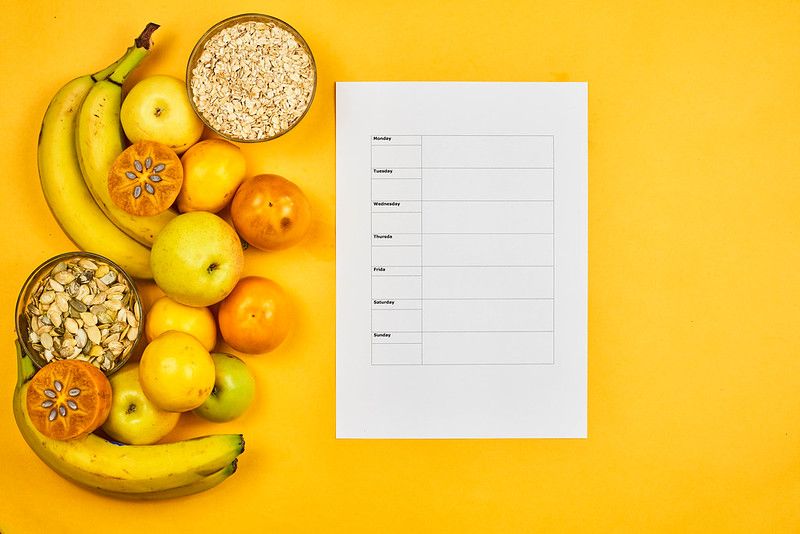 Fruits and nuts next to a weekly meal plan.