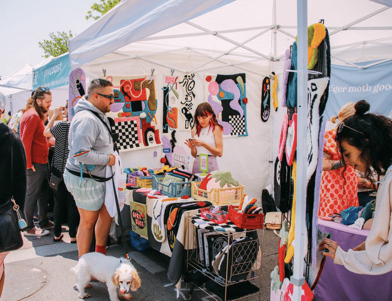 A small business selling hand-made tufted carpets at a fair.