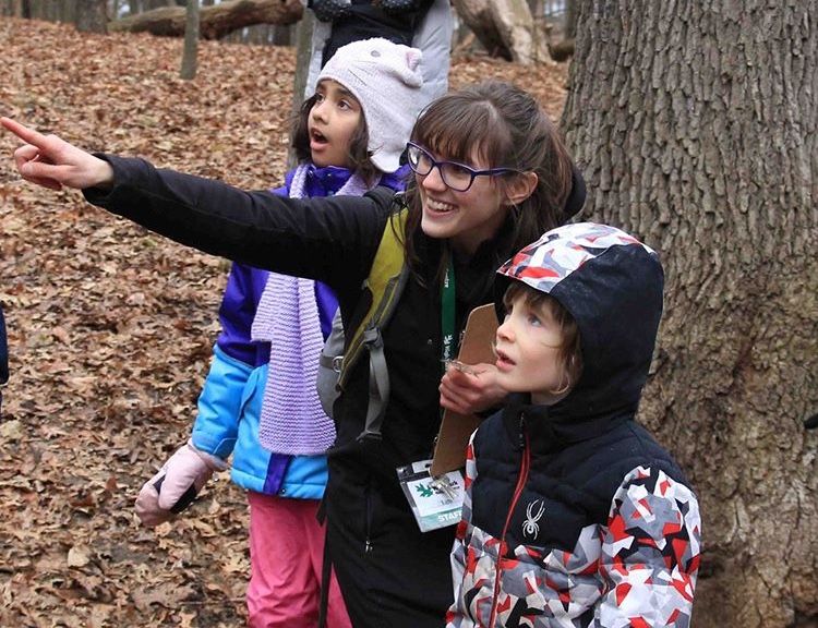 Adult pointing at a bird to show two children