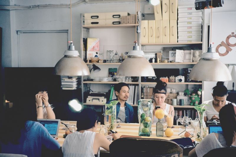 A group of people in a cafe using their devices.