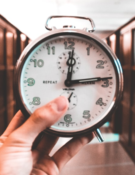 A hand holding a clock.