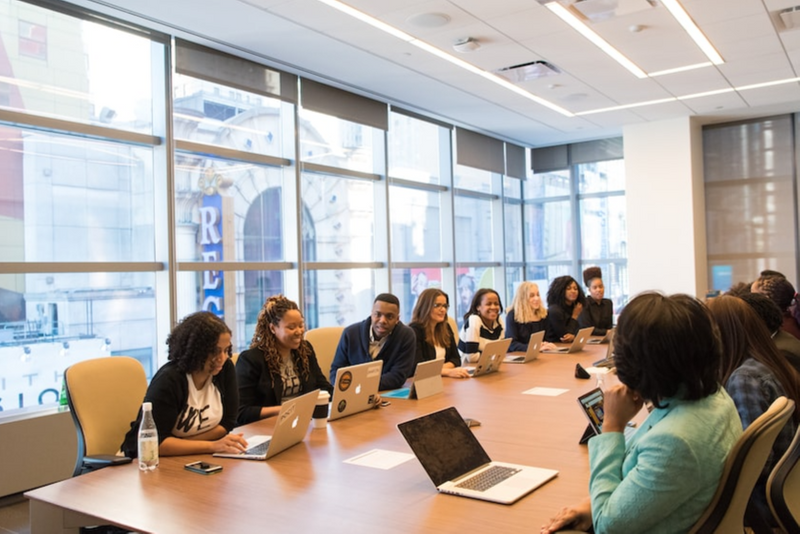 Large group of people meeting at a conference room table