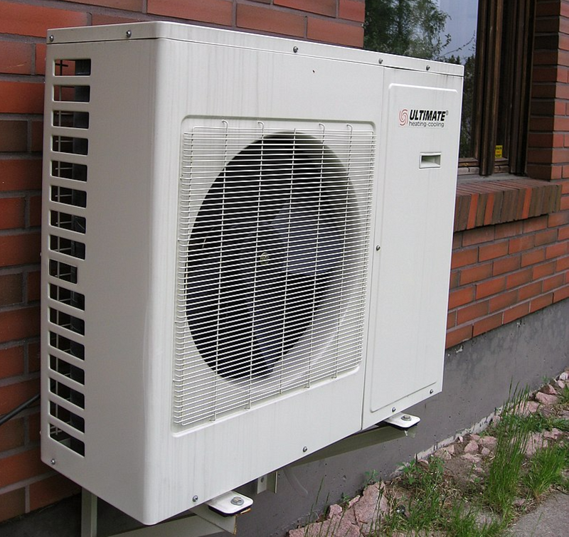 Heat pump on the exterior of a brick building.