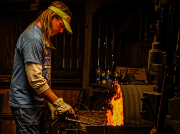 Person using a forge for heating metal.