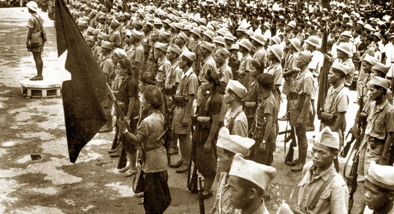 A Viet Minh rally. Soldiers stand in formation and hold the Viet Minh flag.