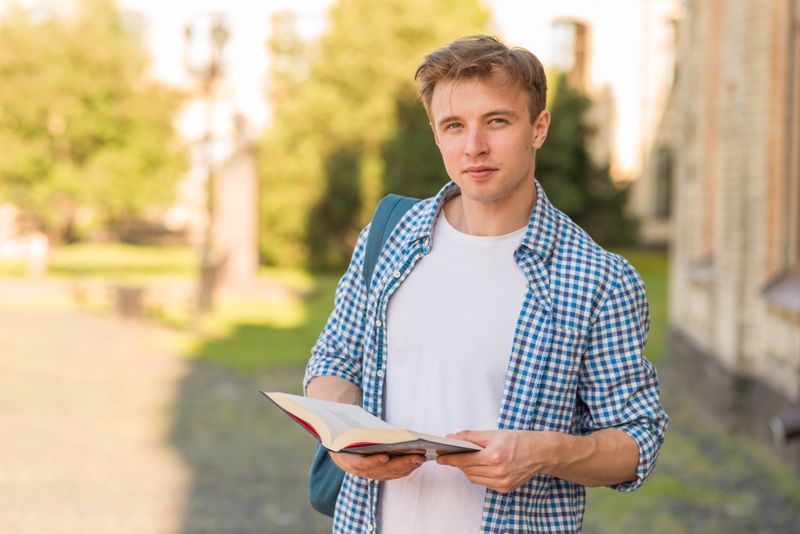 A young man holding an open Bible.