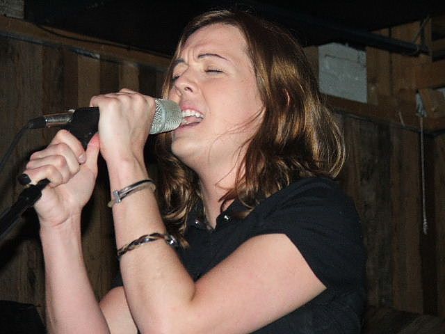 medium shot of Brandi Carlile on stage singing into a microphone