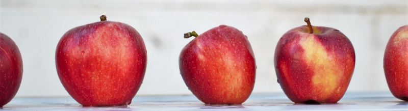 Red apples in a row that all look different.