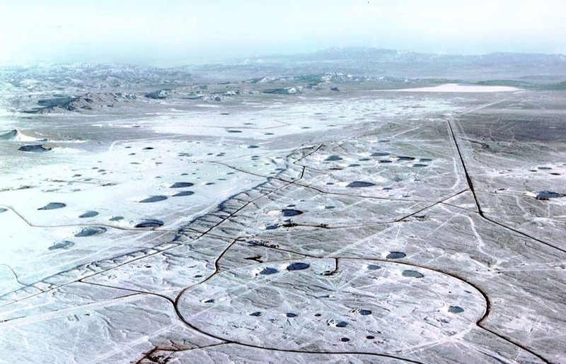 A scarred landscape of a nuclear testing site in the desert.