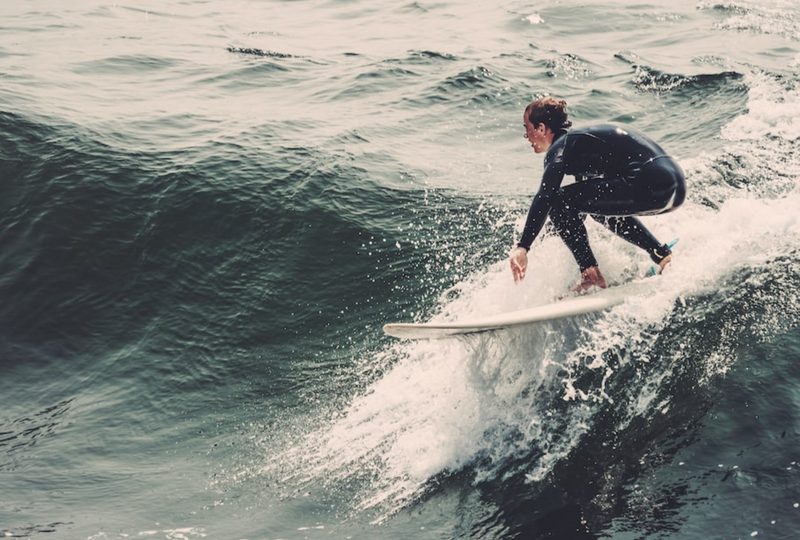 A surfer riding a wave on a grey day.