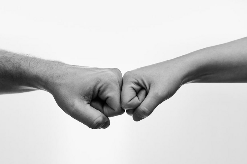 Two fists meeting in a fist bump.