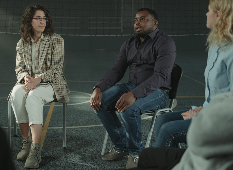 1 man and 2 women sitting in support group circle