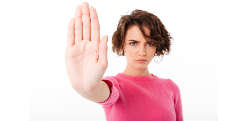 A woman holds up her hand to motion 