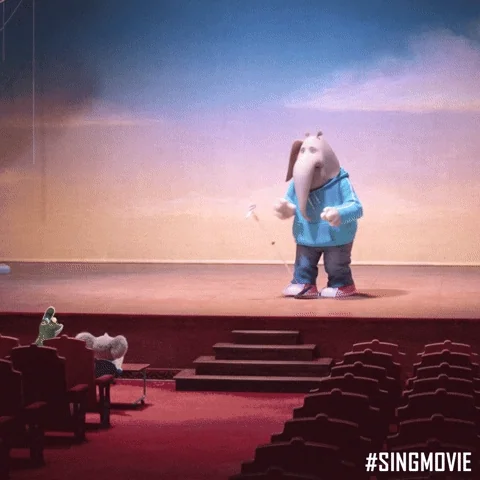 A nervous elephant on stage accidentally knocks over the microphone with its leg.