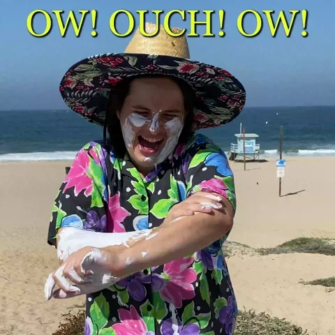 A person applying lots of sunscreen and saying 'Ow! Ouch! Ow! It burns!'