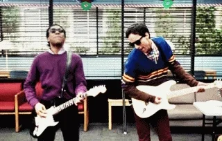 Two men from the TV show 'Community' play the electric guitar.