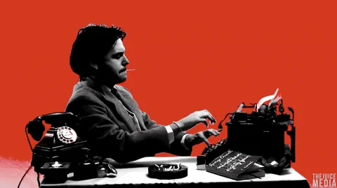 A person typing in a typewriter. The text reads, 