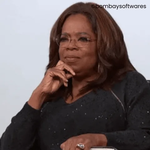 Oprah Winfrey nods her head while actively listening to a speaker.