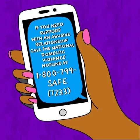 A person holding a phone screen that shows the National Domestic Violence Hotline phone number: 1-800-799-SAFE (7233).
