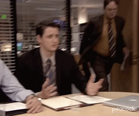 Man enters in office with two men sitting down and slams paper on the table saying 