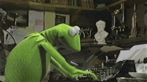 Kermit the Frog frantically typing on a typewriter.