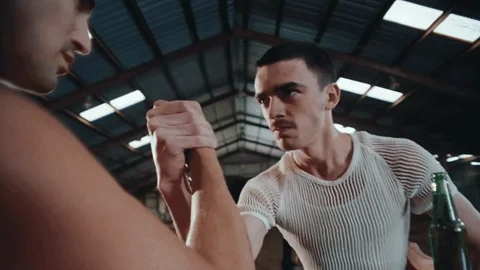 Two people arm wresting.