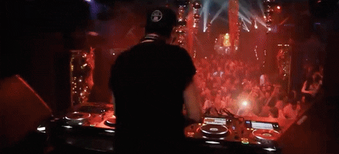 DJ playing music in a club with a crowd