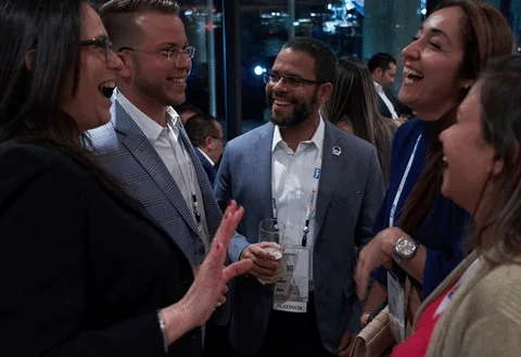 A group of adults at a networking event laughing and talking.