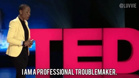 GIF: Person giving Ted Talk says, 'I am a professional troublemaker'