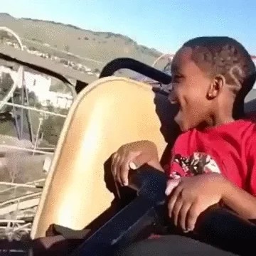 Small male child on roller coaster whose expression goes from excitement to fear.