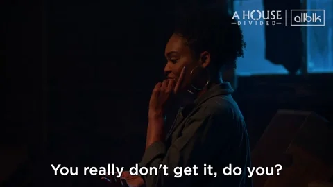 A woman pointing to her head and saying,