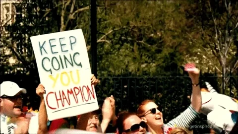 A person at a marathon holding a sign that says: