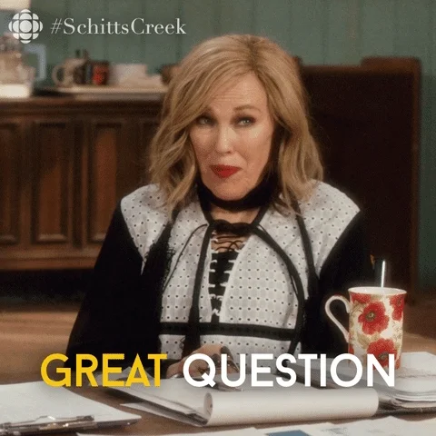 Moira from Schitt's Creek sitting in front of a table with notes. She says, 
