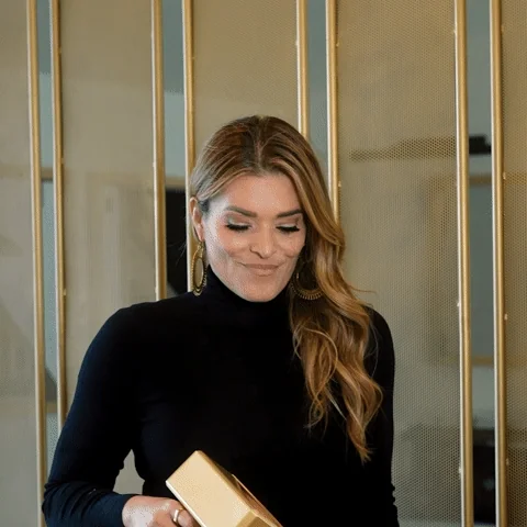 A woman shooting out money from a golden gun.