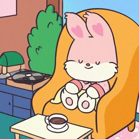 A bunny sitting in a chair listening to a record with a coffee.