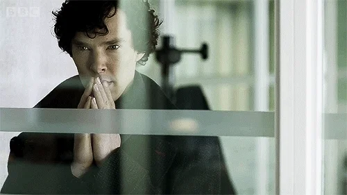 Sherlock Holmes twiddling his fingers and thinking.