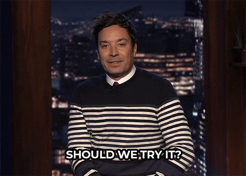 Jimmy Fallon shrugging his shoulders and raising his hands, with 
