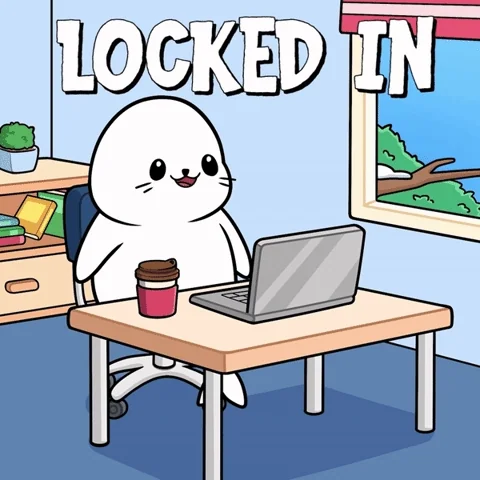 A white seal sitting at a desk with a laptop and coffee. The text reads: 