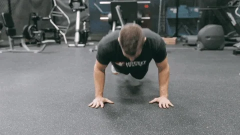 A person doing push ups in a gym using proper form.