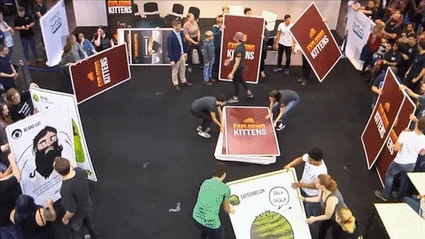 People playing a game with human-sized cards.