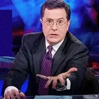 Stephen Colbert holding out his hand, saying 