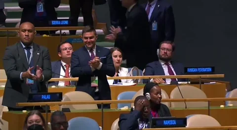 Delegates clap at a UN meeting.