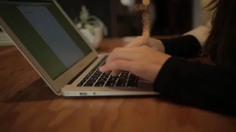 Hands typing on a keyboard, representing a teacher writing a lesson plan.