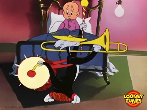  Elmer Fudd in bed watching Sylvester cat march back and forth playing trumpet and drum.