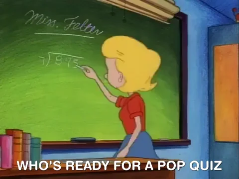 A female teacher at a blackboard with text that reads: “Who’s ready for a pop quiz!”