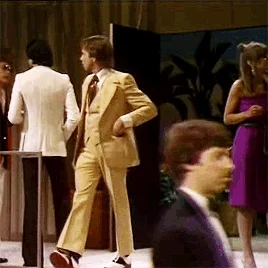 Distracted person in 70s suit trips and falls down stairs