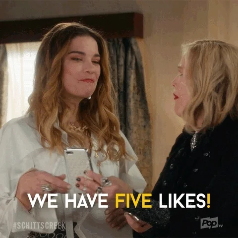  Moira and Alexis from Schitt's Creek looking at a mobile phone, with Moira saying, 'We have five likes!'