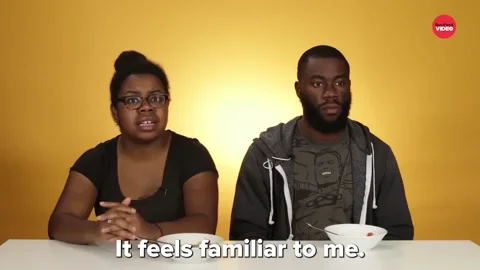 A black man and woman sitting at a table with cereal bowls. The woman says, 