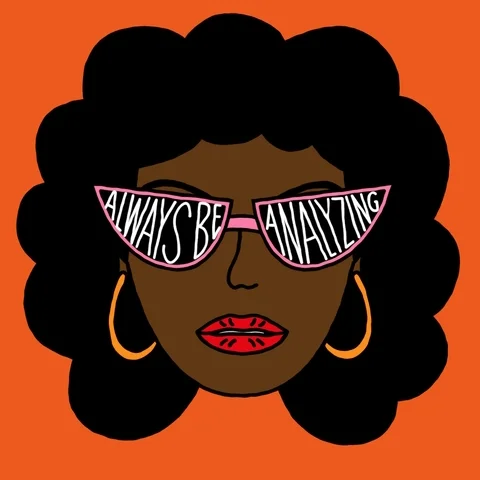 A woman with curly hair and hoop earrings, as well as wearing sunglasses that says: 