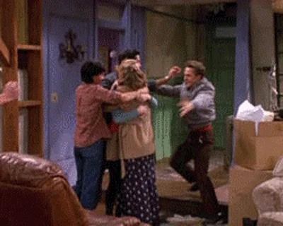 Friends TV show characters going in for a group hug.